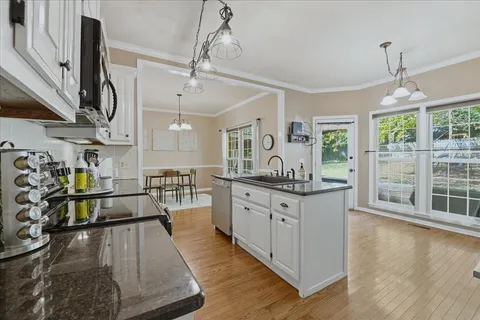 a large kitchen with stainless steel appliances lots of counter space and a wooden floor