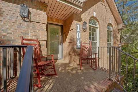a view of a brick house with wooden floor and fence