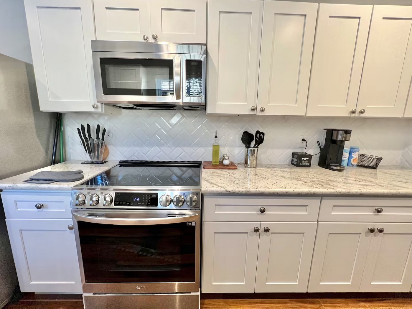 1508 Ridgewood Street, Unit A Houston, TX 77006 - Photo 3 of 16 a kitchen with granite countertop white cabinets and stainless steel appliances