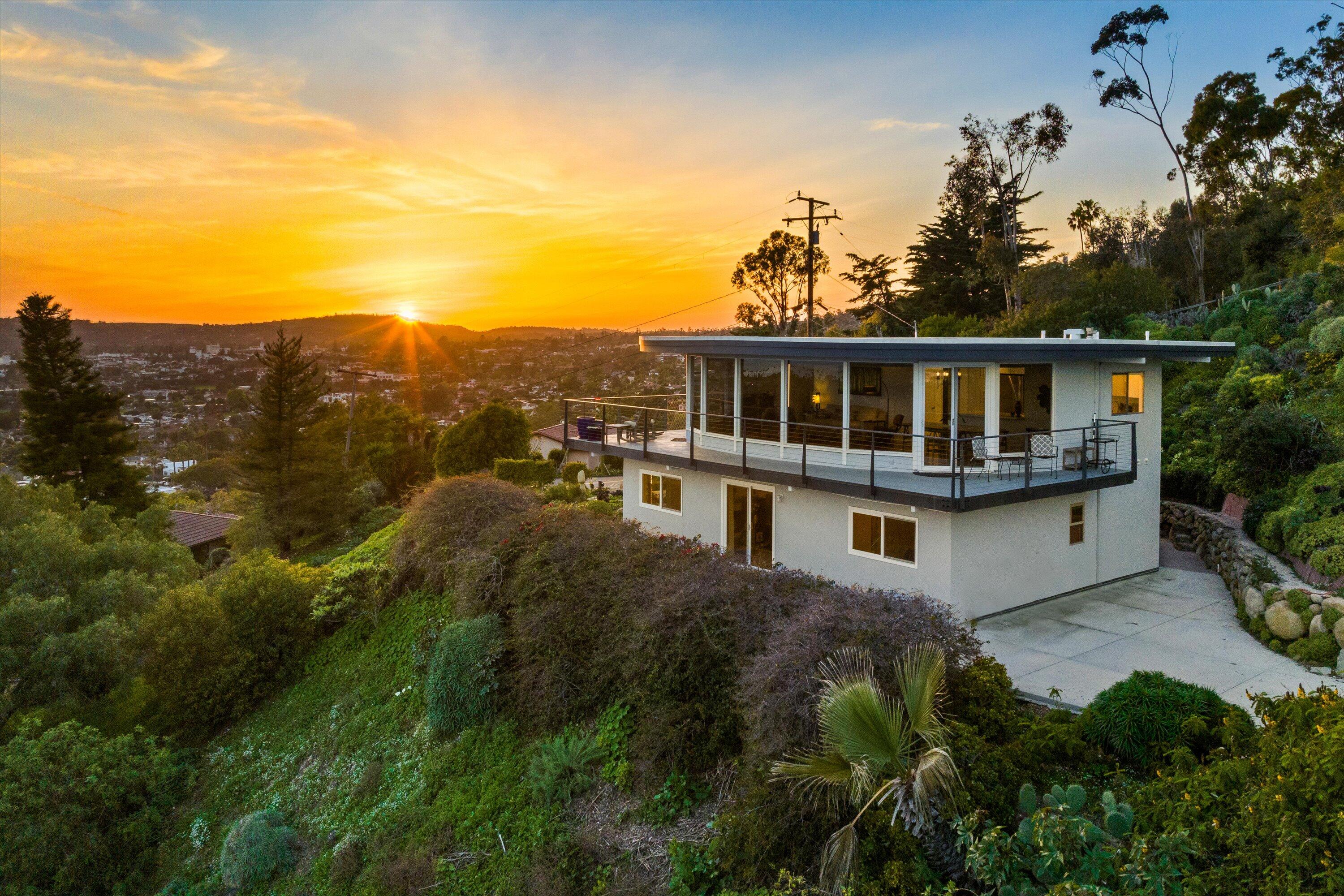 a view of a house with a garden and wooden fence