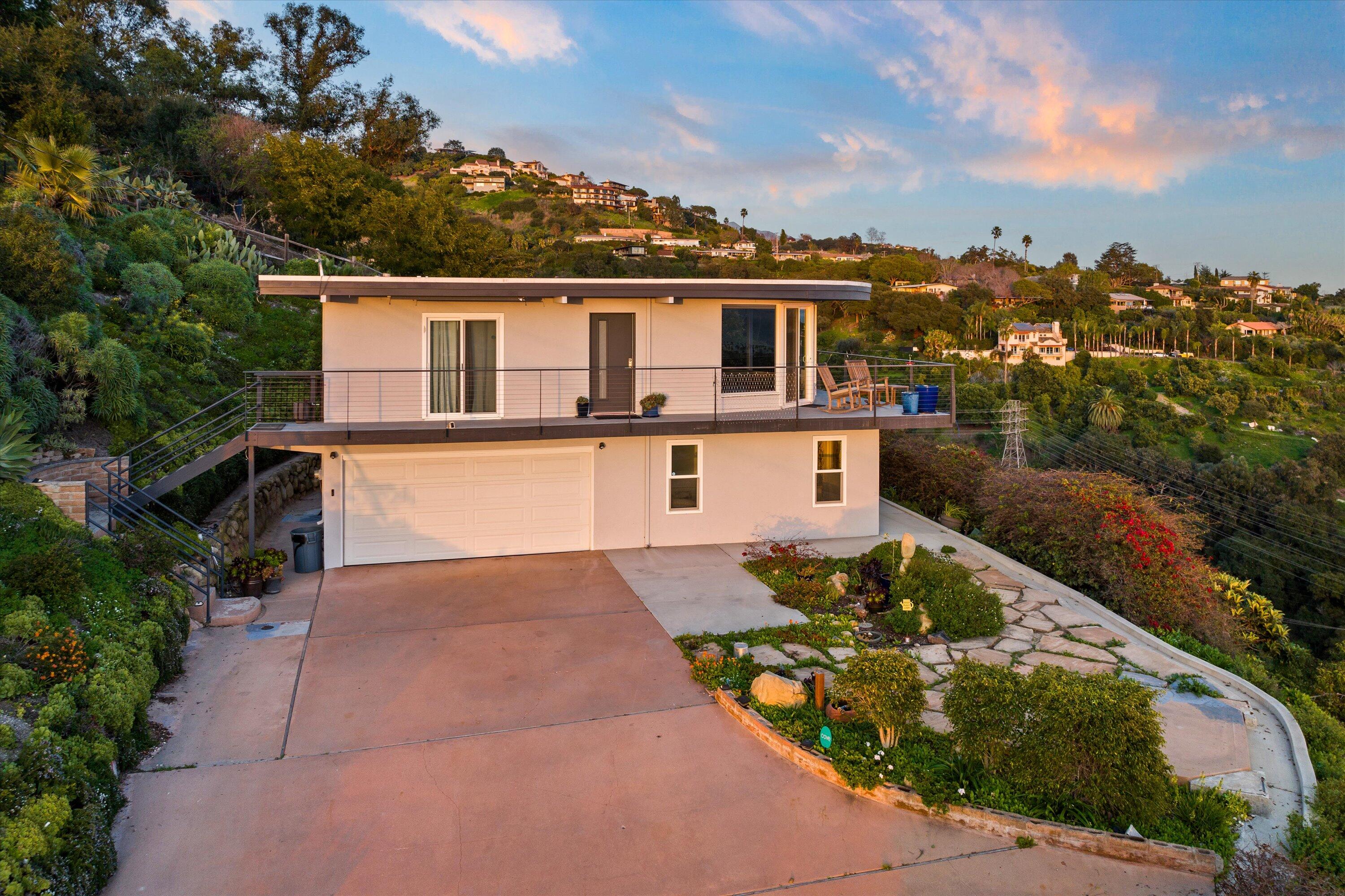 128 Las Alturas Road Santa Barbara, CA 93103 - Photo 16 of 36 a front view of a house with a yard and potted plants
