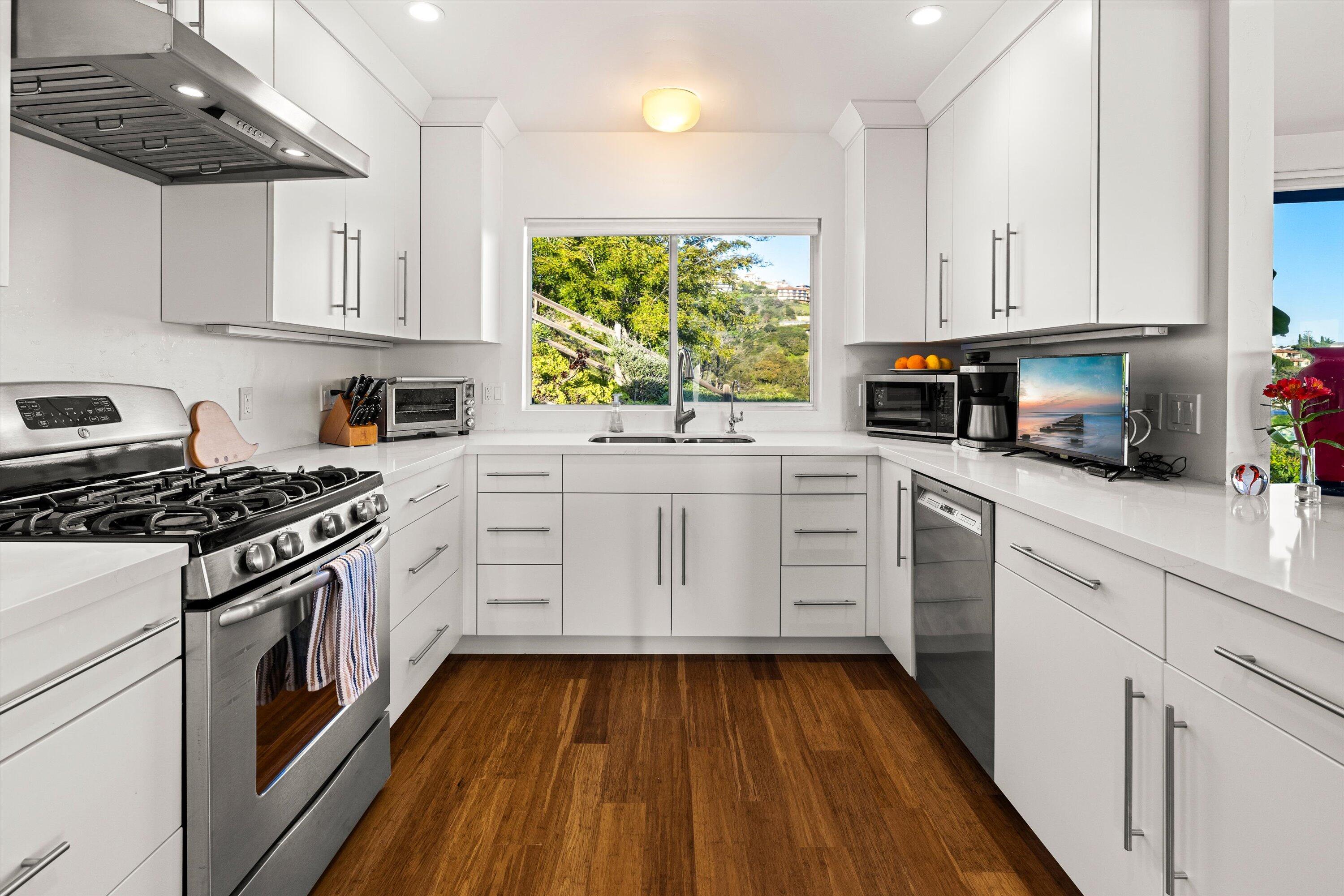 128 Las Alturas Road Santa Barbara, CA 93103 - Photo 9 of 36 a kitchen with white cabinets appliances and a window