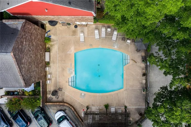 an aerial view of a house with swimming pool and large trees