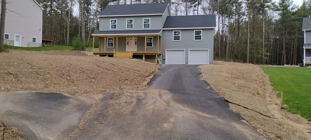 a view of a house with a yard and large tree