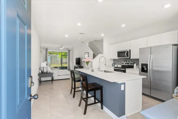 a kitchen with stainless steel appliances a table and chairs in it