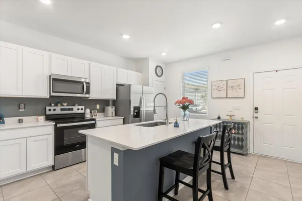 a kitchen with a stove a sink a microwave and a refrigerator