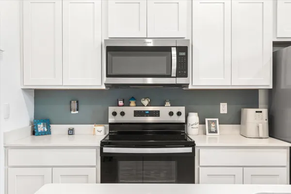 a kitchen with stainless steel appliances granite countertop a stove microwave and cabinets