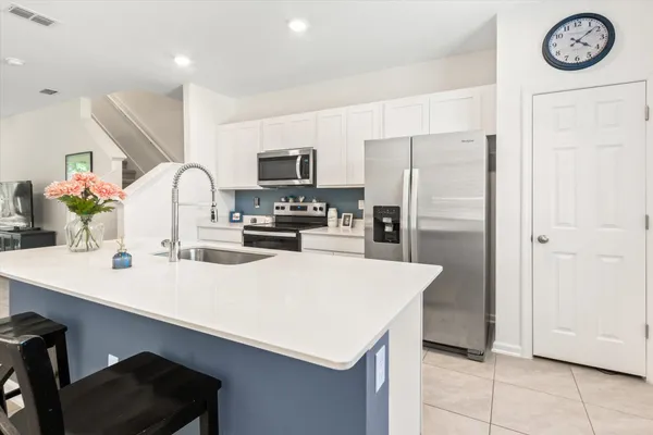 a kitchen with kitchen island a refrigerator stove and sink