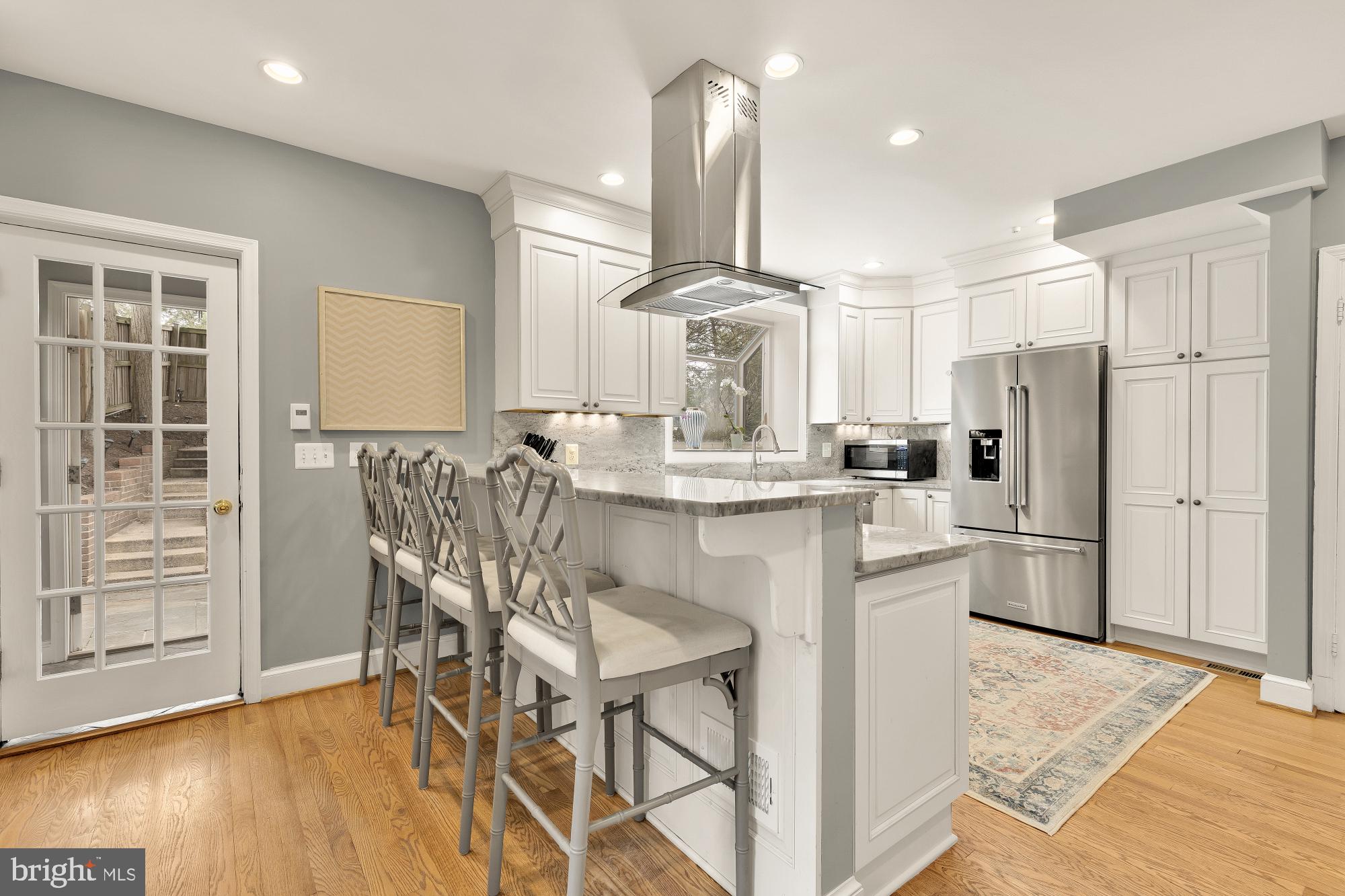4109 17th Street Northwest Washington, DC 20011 - Photo 18 of 47 a kitchen with stainless steel appliances kitchen island granite countertop a refrigerator a stove a kitchen island with a dining table and chairs