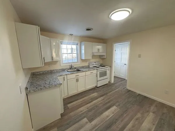 a kitchen with white cabinets and white appliances