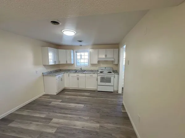 a large kitchen with a stove top oven sink and cabinets