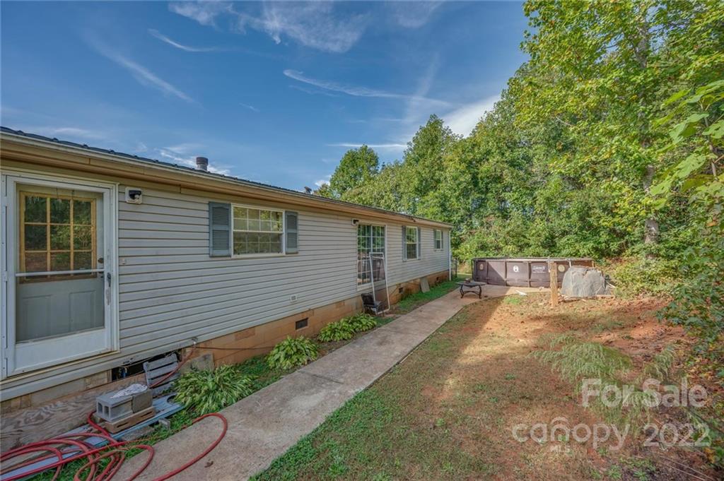 280 Highway 9 Mill Spring, NC 28756 - Photo 2 of 18 a view of a backyard with potted plants and wooden fence
