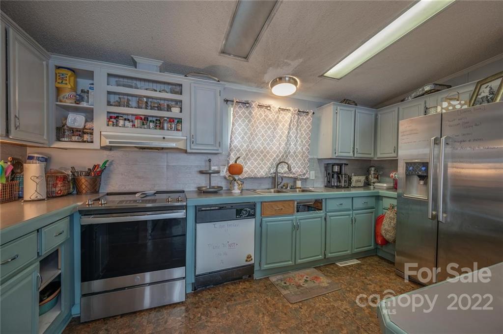 280 Highway 9 Mill Spring, NC 28756 - Photo 6 of 18 a kitchen with stainless steel appliances granite countertop a stove a sink and a refrigerator