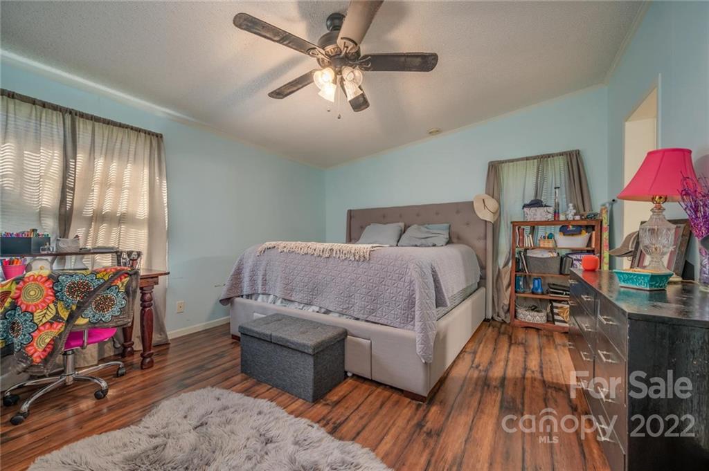 280 Highway 9 Mill Spring, NC 28756 - Photo 8 of 18 a bedroom with a bed and wooden floor