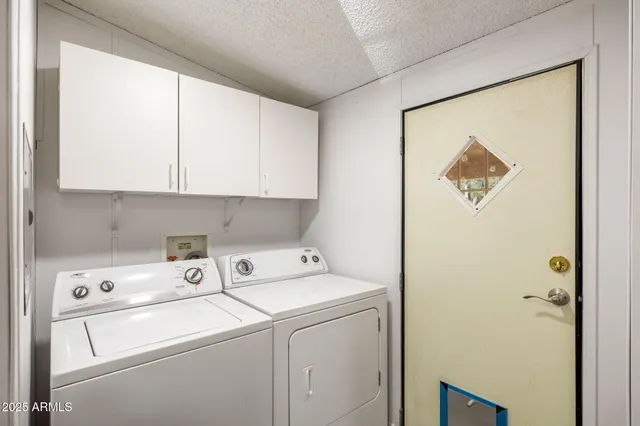 a view of washer and dryer with kitchen in the background