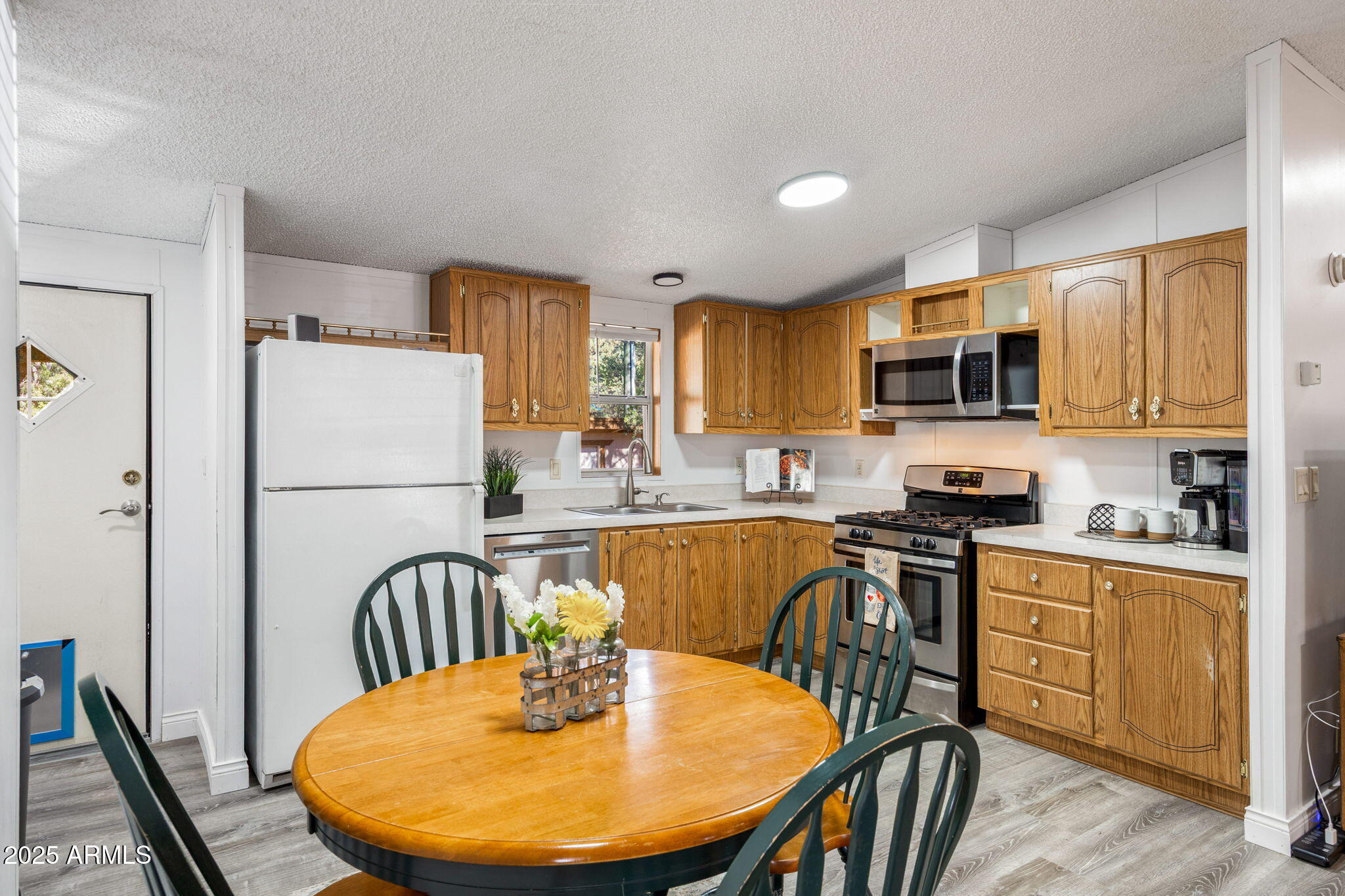 2064 Pinewood Drive Overgaard, AZ 85933 - Photo 10 of 33 a kitchen with stainless steel appliances granite countertop a stove a sink a microwave a refrigerator a dining table and chairs