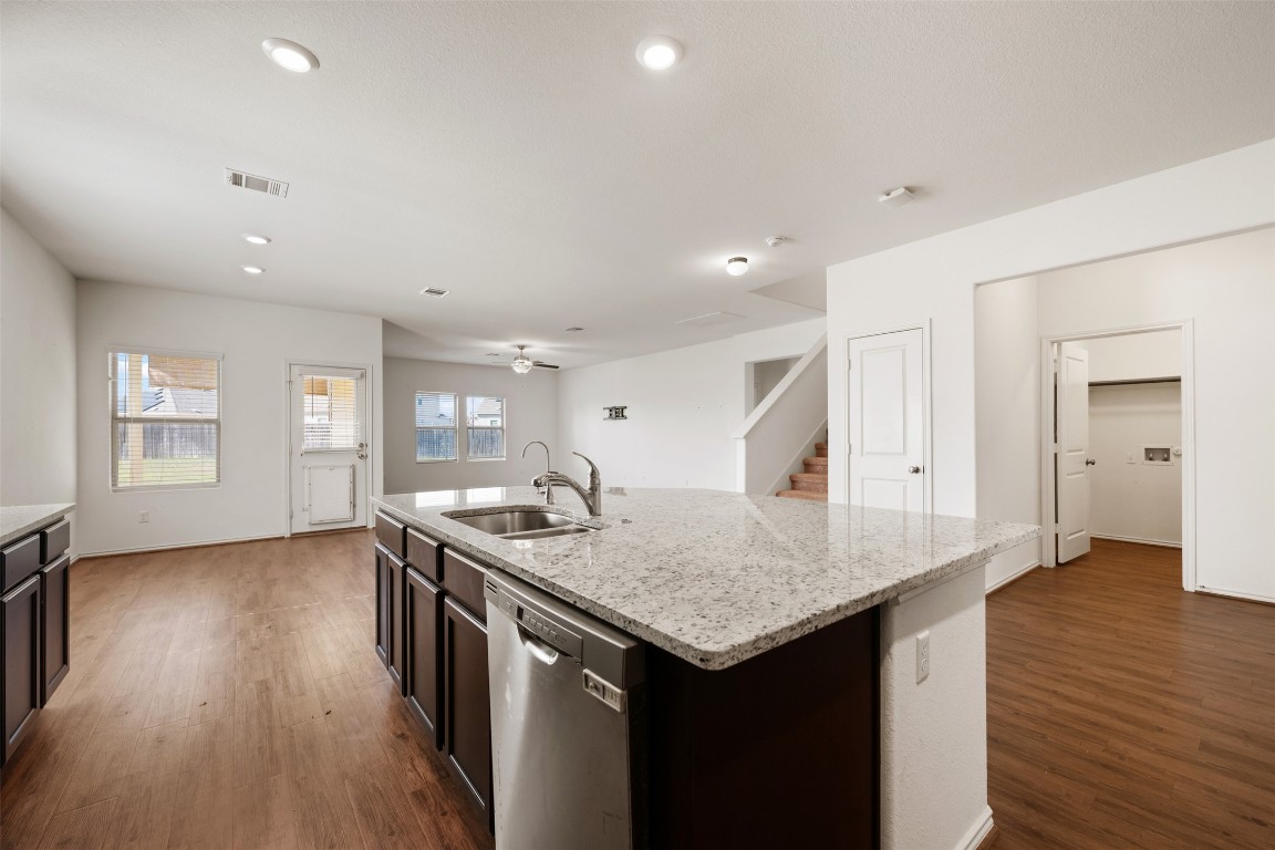 160 Copper Lane Kyle, TX 78640 - Photo 12 of 40 an open kitchen with a sink and dishwasher with kitchen island