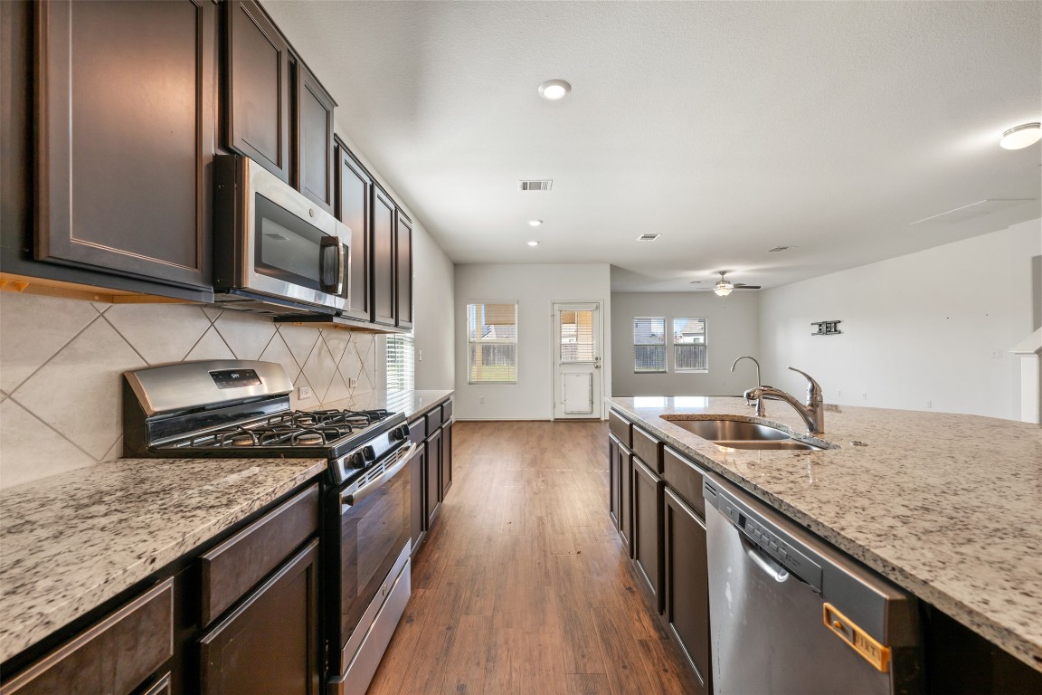 160 Copper Lane Kyle, TX 78640 - Photo 13 of 40 a kitchen with granite countertop stainless steel appliances and wooden cabinets