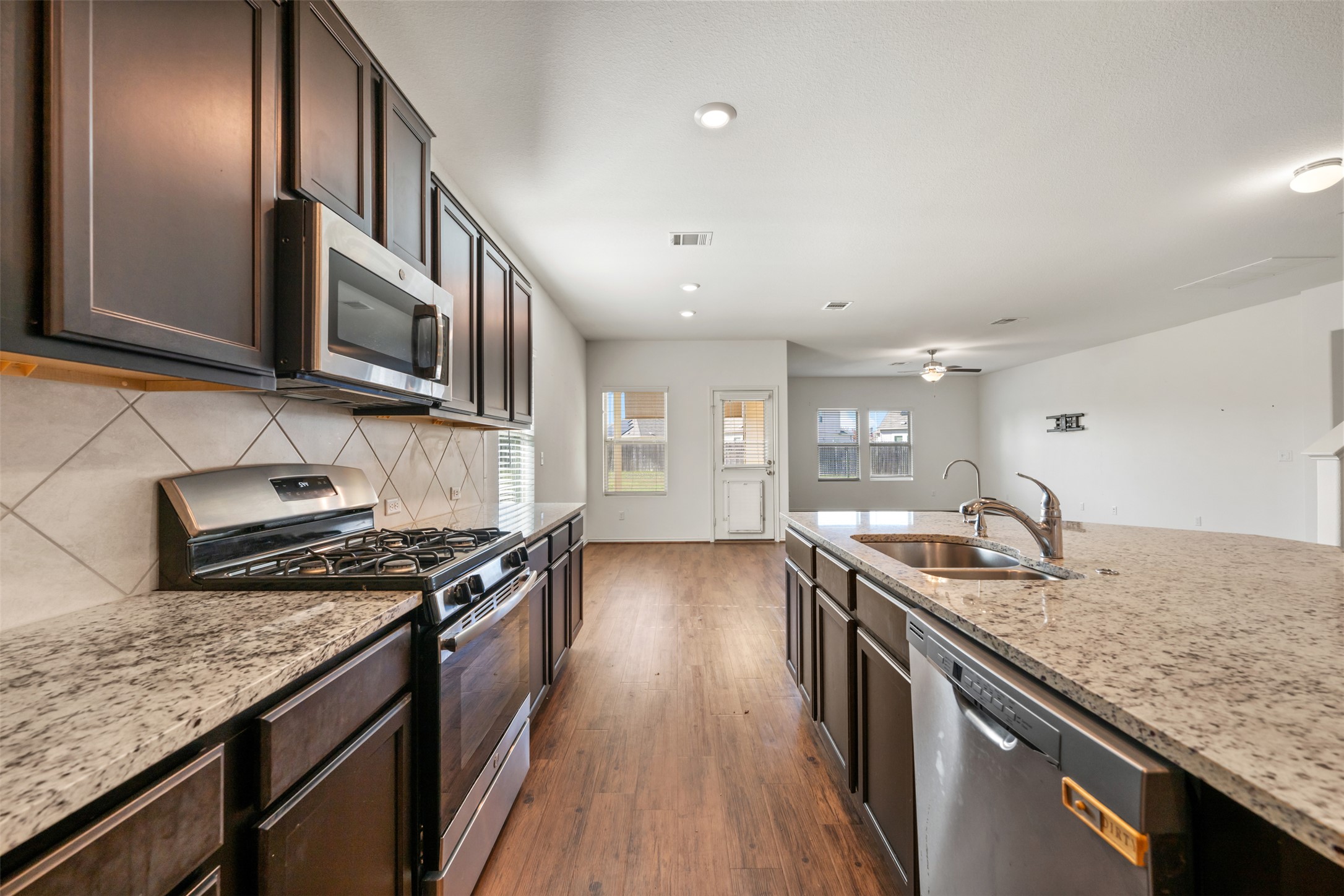 160 Copper Lane Kyle, TX 78640 - Photo 13 of 40 a kitchen with granite countertop stainless steel appliances and wooden cabinets