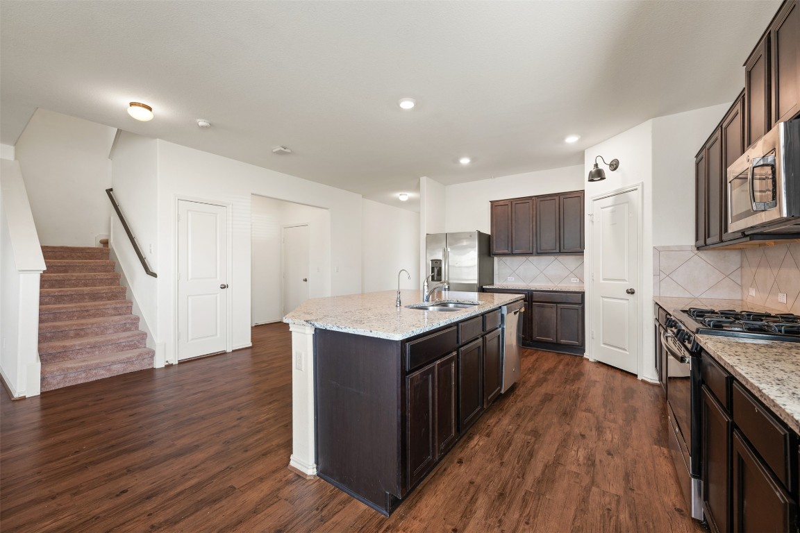 160 Copper Lane Kyle, TX 78640 - Photo 15 of 40 a kitchen with wooden floors and stainless steel appliances