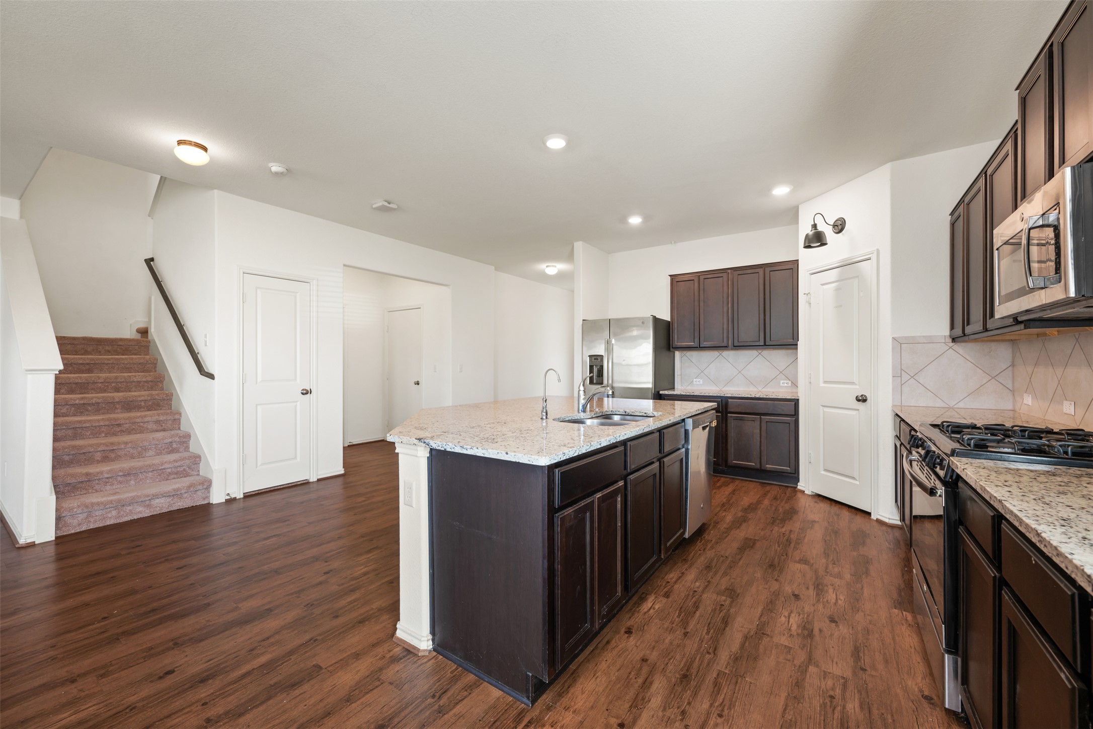 160 Copper Lane Kyle, TX 78640 - Photo 15 of 40 a kitchen with wooden floors and stainless steel appliances