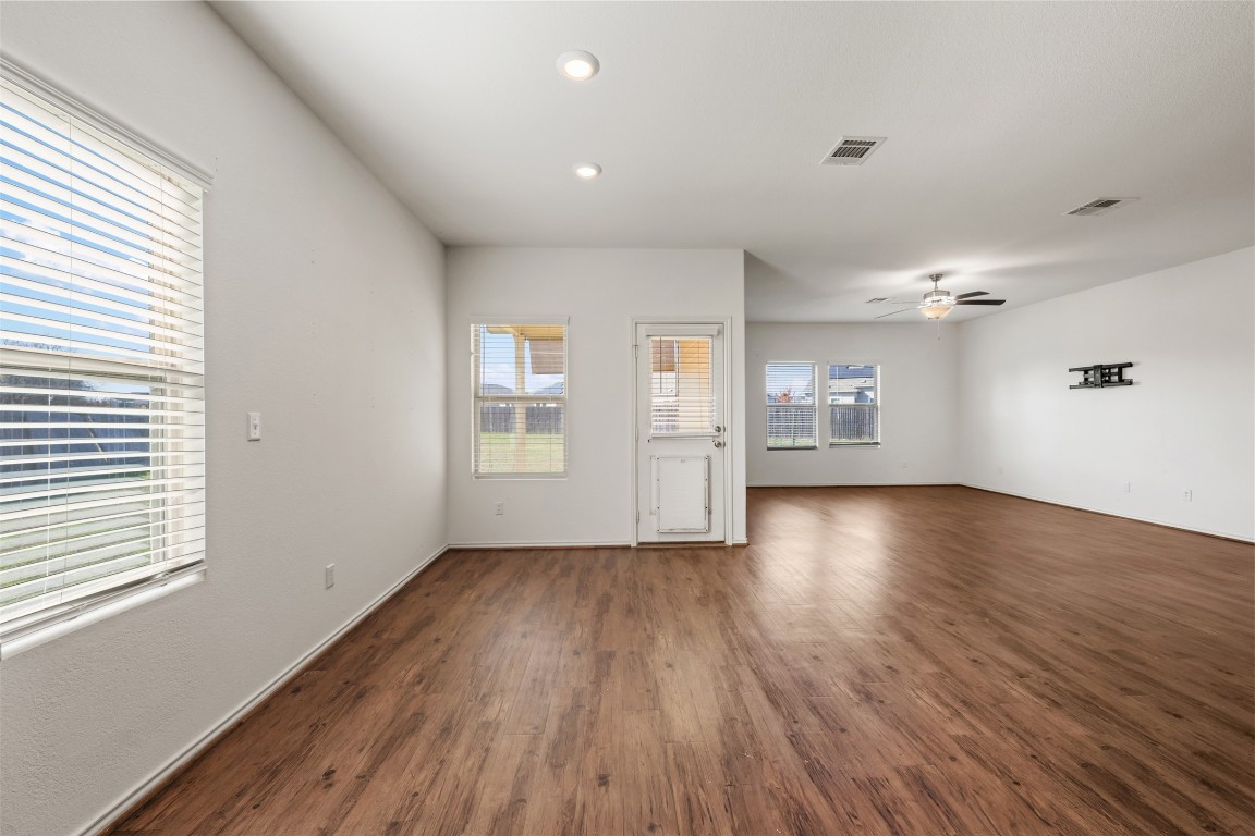 160 Copper Lane Kyle, TX 78640 - Photo 16 of 40 an empty room with wooden floor kitchen view and windows