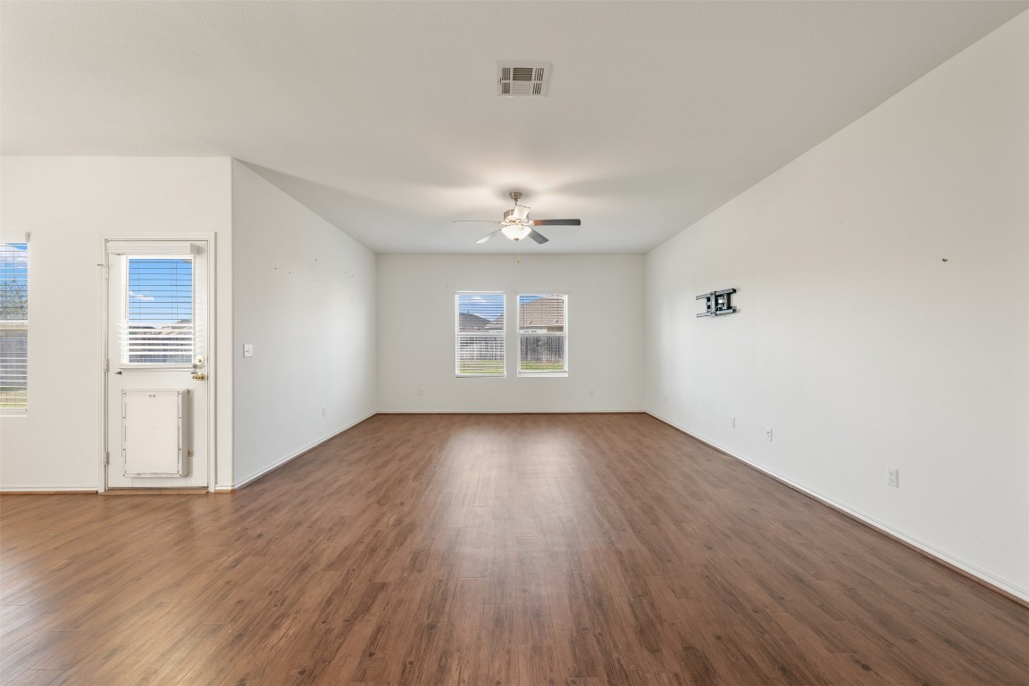 160 Copper Lane Kyle, TX 78640 - Photo 20 of 40 an empty room with wooden floor chandelier and windows