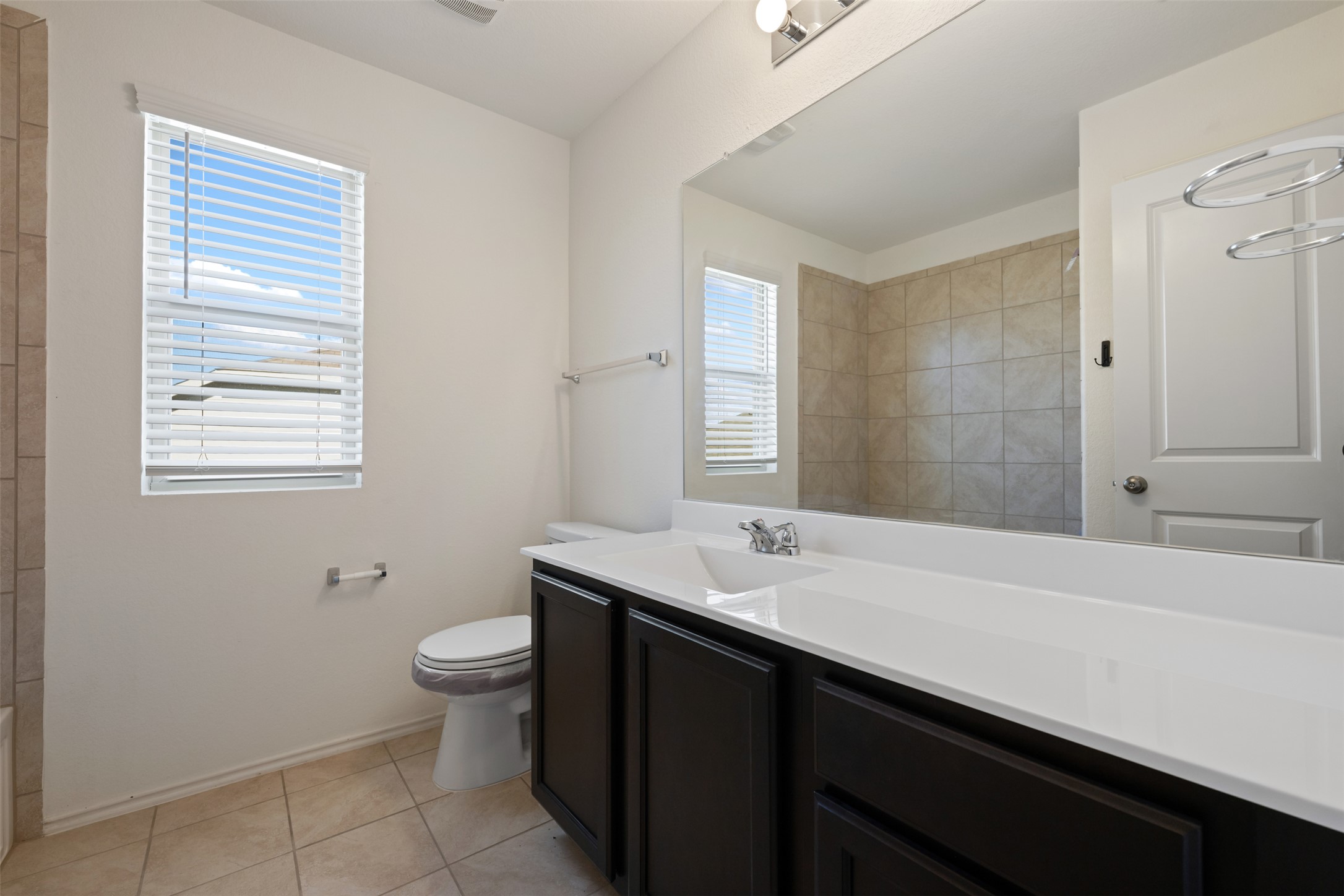 160 Copper Lane Kyle, TX 78640 - Photo 36 of 40 a bathroom with a sink a toilet a mirror and a window