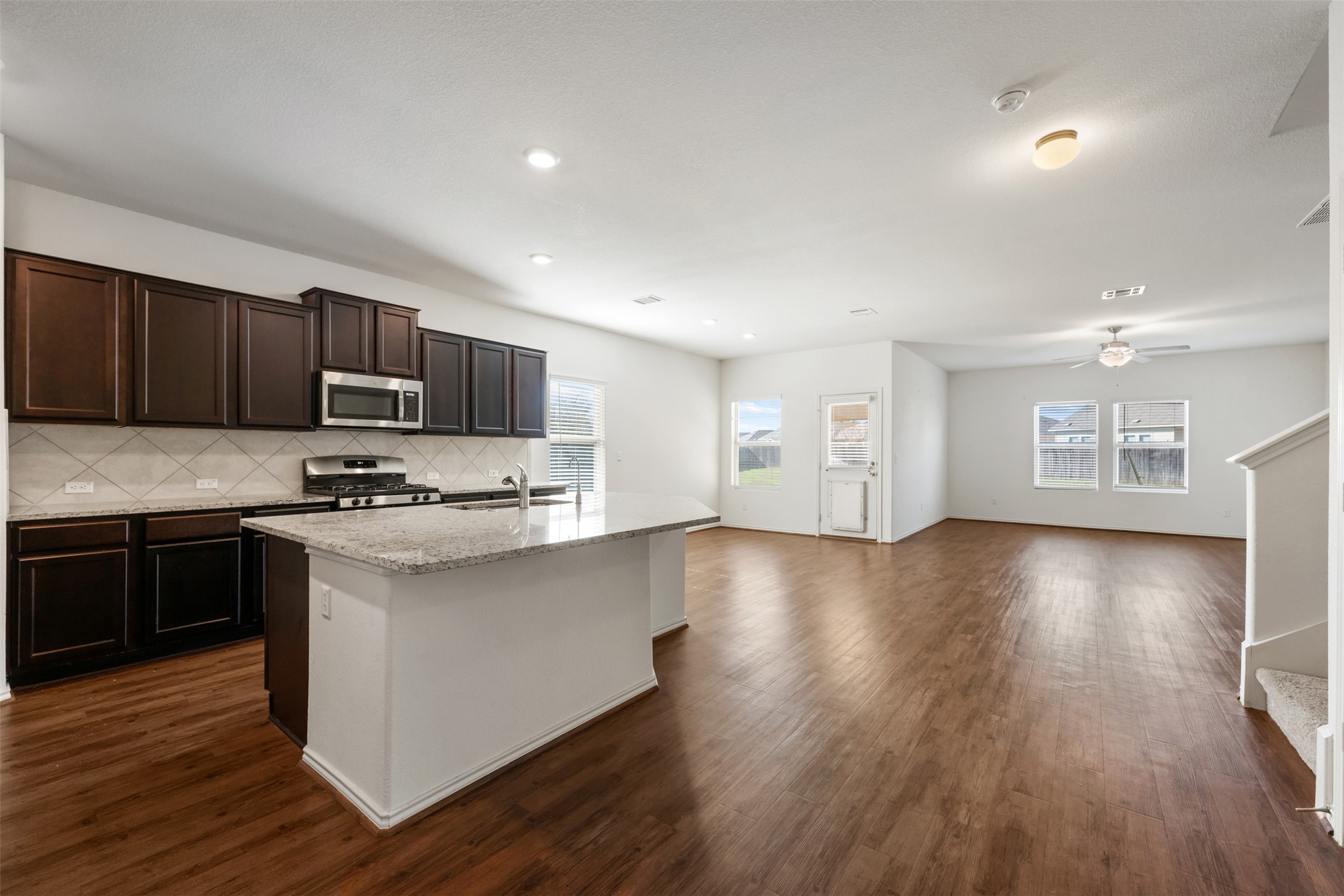 160 Copper Lane Kyle, TX 78640 - Photo 8 of 40 a kitchen with stainless steel appliances granite countertop a stove and a wooden floors