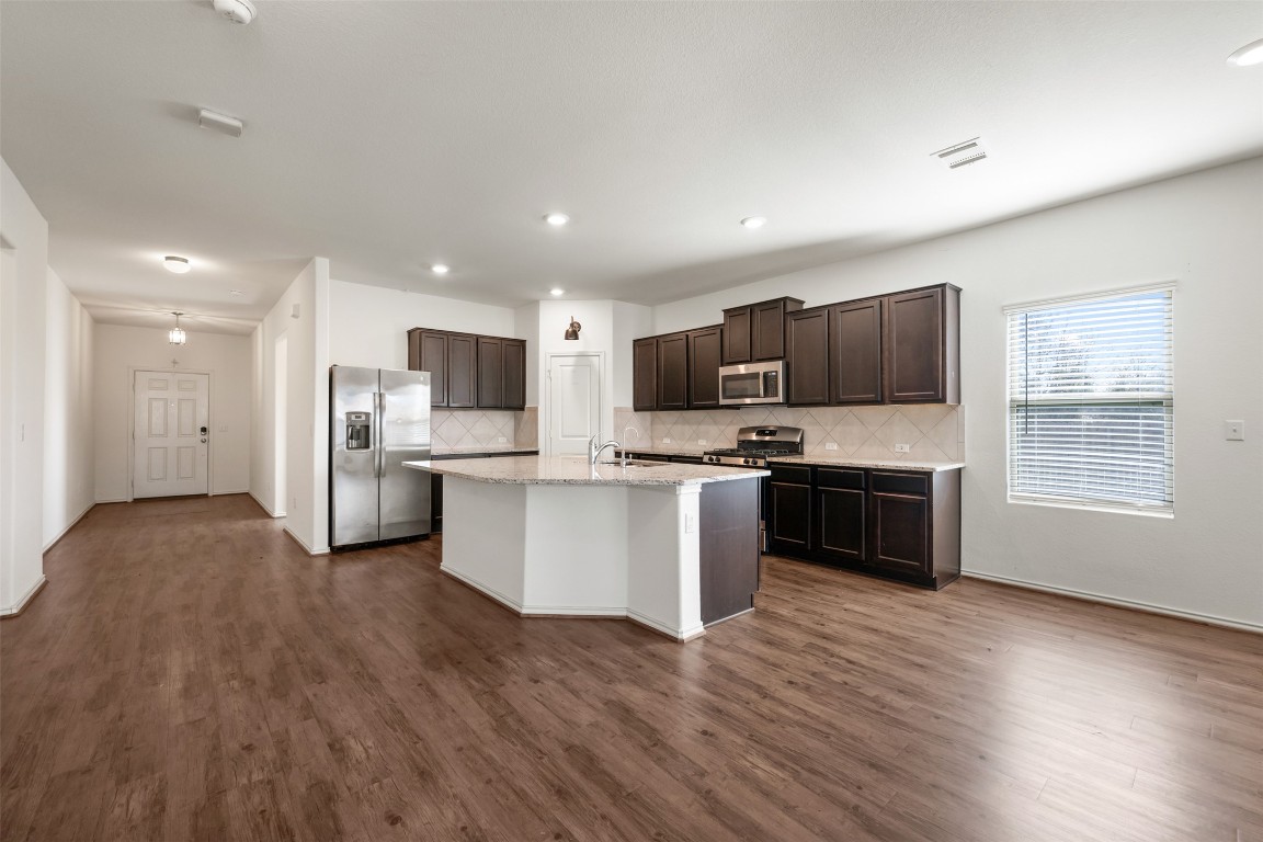 160 Copper Lane Kyle, TX 78640 - Photo 9 of 40 a kitchen with stainless steel appliances kitchen island wooden cabinets and granite counter tops