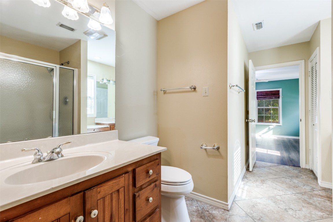 106 Redbud Drive Spicewood, TX 78669 - Photo 15 of 35 a bathroom with a sink a toilet a shower and a mirror