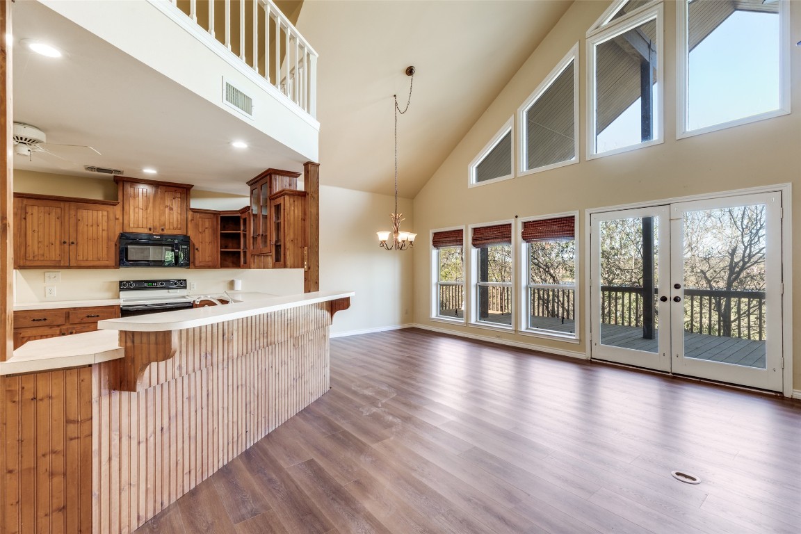 106 Redbud Drive Spicewood, TX 78669 - Photo 10 of 35 a large kitchen with stainless steel appliances granite countertop a large window and wooden floor