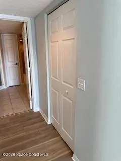 a view of a hallway with wooden floor and closet