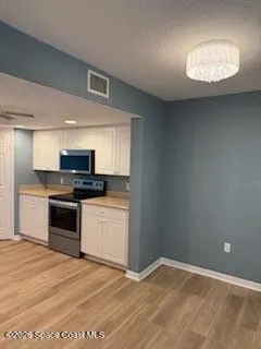 a kitchen with granite countertop a stove cabinets and wooden floor