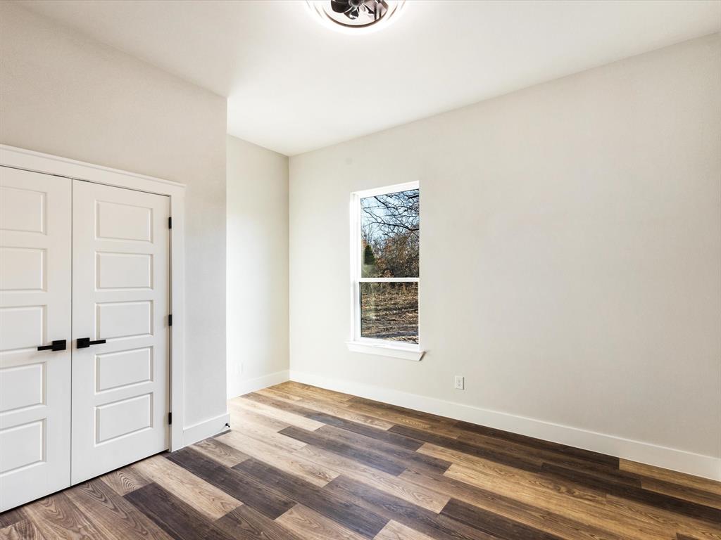 5018 Point La Vista Road Malakoff, TX 75148 - Photo 20 of 32 Unfurnished bedroom featuring a closet and wood finished floors