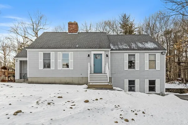 a front view of a house with a yard covered in snow
