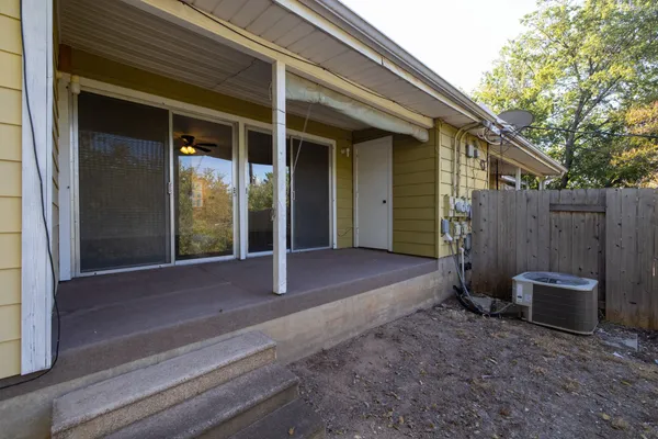 a view of backyard with small cabin and wooden fence