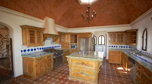 a dining hall with stainless steel appliances granite countertop a stove and cabinets