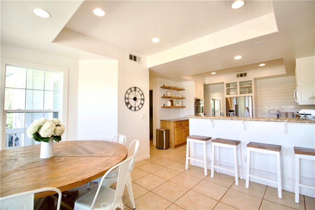 35159 El Dorado Road Lake Elsinore, CA 92530 - Photo 23 of 72 a kitchen with stainless steel appliances kitchen island granite countertop a table and chairs in it