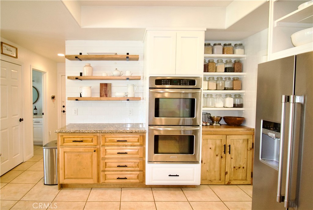 35159 El Dorado Road Lake Elsinore, CA 92530 - Photo 26 of 72 a kitchen with stainless steel appliances a stove a refrigerator and cabinets