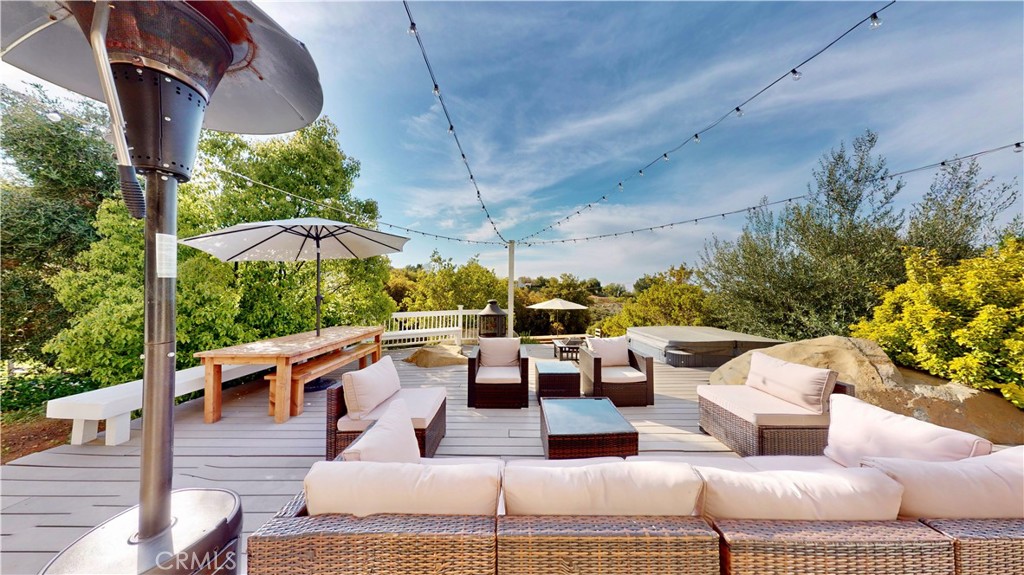 35159 El Dorado Road Lake Elsinore, CA 92530 - Photo 43 of 72 a view of a patio with couches table and chairs under an umbrella with a barbeque