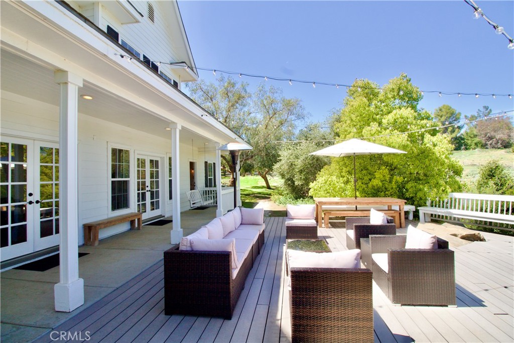 35159 El Dorado Road Lake Elsinore, CA 92530 - Photo 44 of 72 a view of a patio with couches and table and chairs with wooden floor and fence