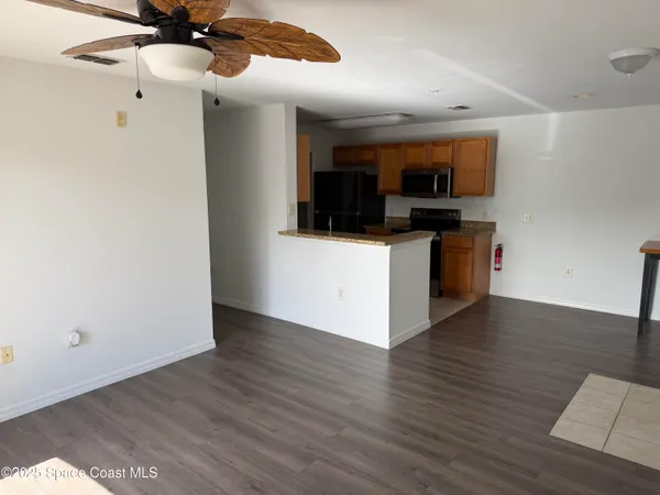 a view of kitchen with stainless steel appliances granite countertop a refrigerator and a sink