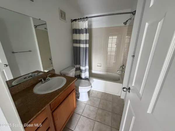 a bathroom with a sink a toilet a mirror and shower