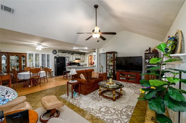 a living room with furniture a flat screen tv and a potted plant