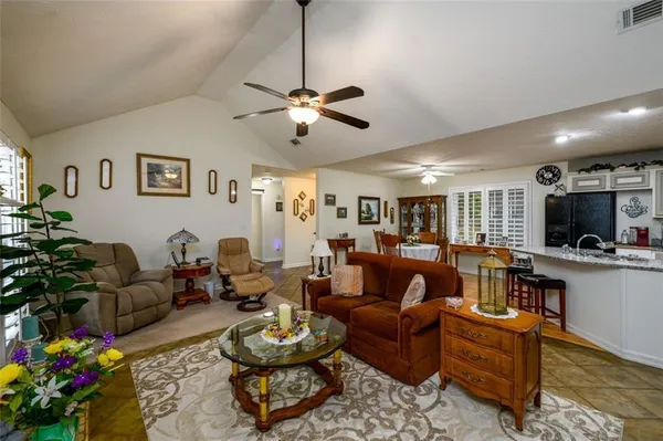 a living room with furniture kitchen view and a window