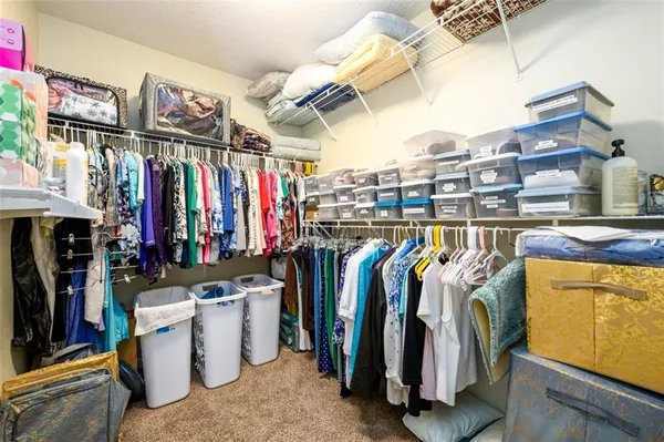 a view of walk in closet with clothes and shoes