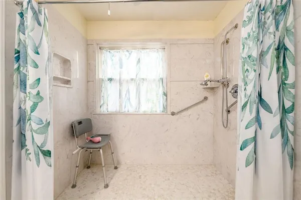 a bath room with a window and a table chair
