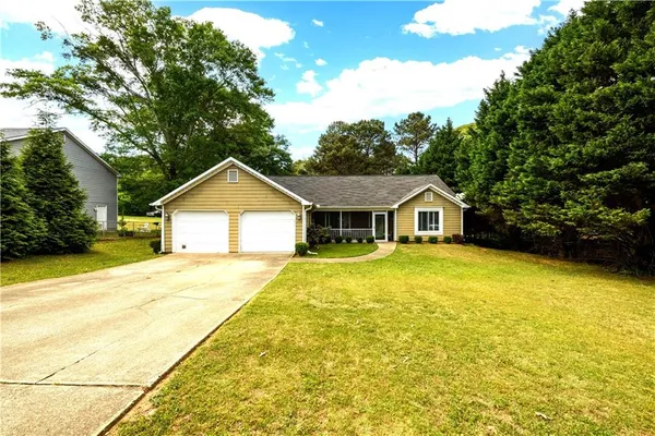 a front view of a house with yard and green space