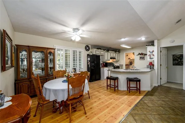 a living room with furniture a dining table and a refrigerator